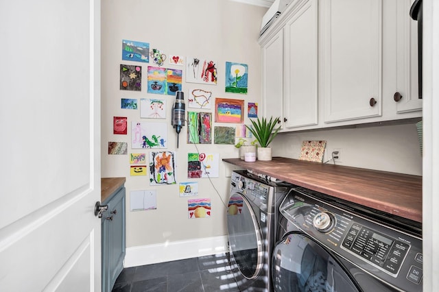 clothes washing area featuring washer and dryer and cabinets