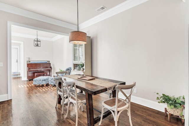 dining room with dark hardwood / wood-style flooring and ornamental molding