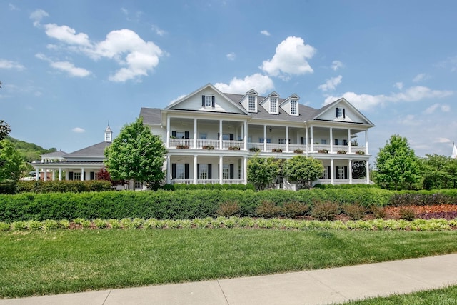 view of front facade with a balcony and a front yard