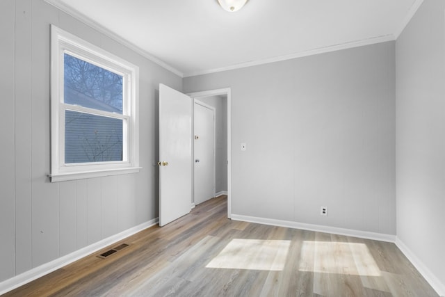 unfurnished room with crown molding and light wood-type flooring