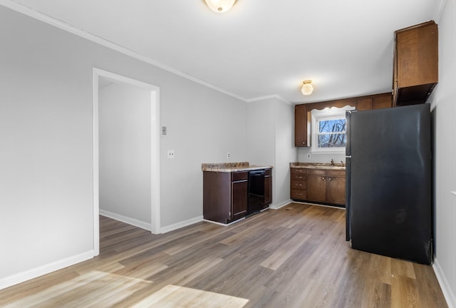 kitchen with refrigerator, black dishwasher, dark brown cabinetry, light hardwood / wood-style floors, and crown molding