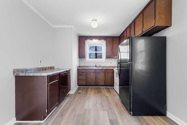 kitchen with dark brown cabinetry, crown molding, light hardwood / wood-style flooring, and black appliances