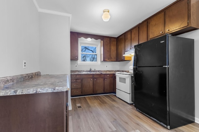 kitchen featuring sink, crown molding, white range with electric cooktop, black fridge, and light wood-type flooring