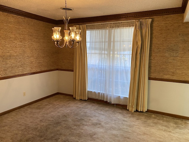 carpeted spare room with a textured ceiling and an inviting chandelier