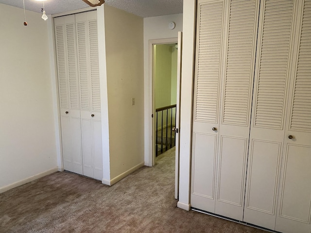 hallway with carpet floors and a textured ceiling