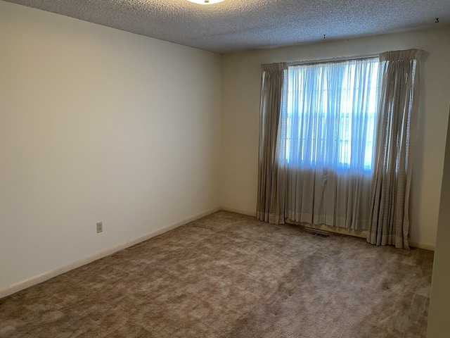 carpeted spare room featuring a textured ceiling