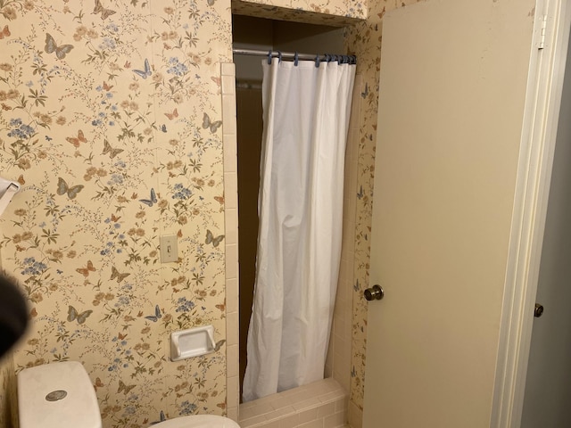 bathroom with a shower with shower curtain and toilet