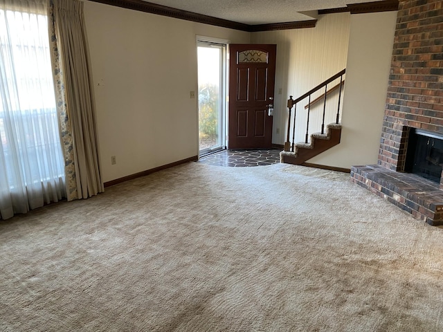 foyer entrance with a brick fireplace, dark carpet, plenty of natural light, and a textured ceiling