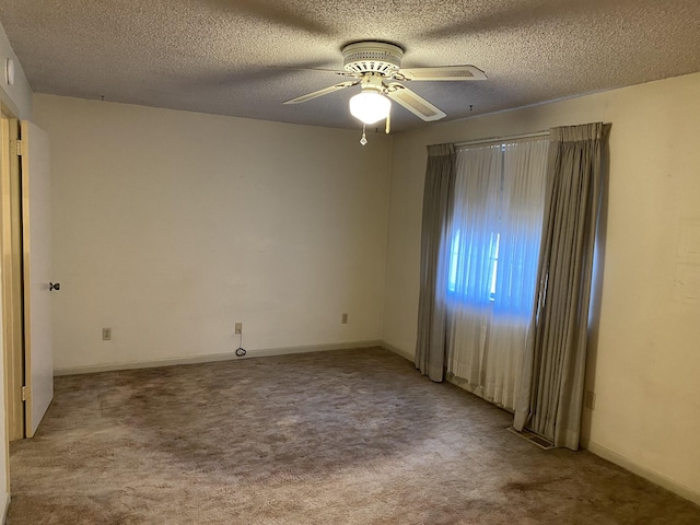 spare room with ceiling fan, light colored carpet, and a textured ceiling