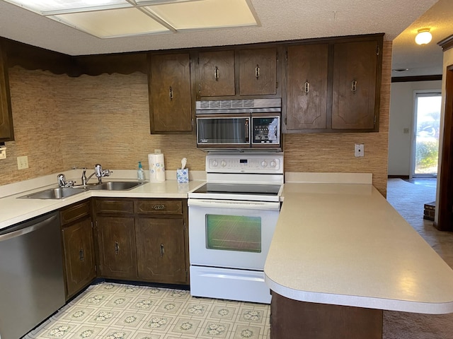 kitchen with dark brown cabinetry, sink, electric range, dishwasher, and kitchen peninsula