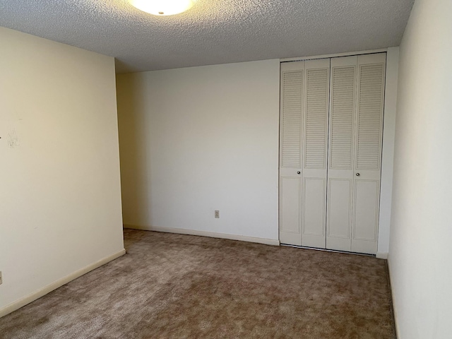 unfurnished bedroom with a closet, a textured ceiling, and carpet flooring