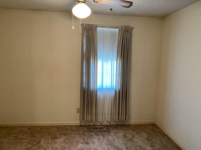 carpeted spare room featuring a textured ceiling