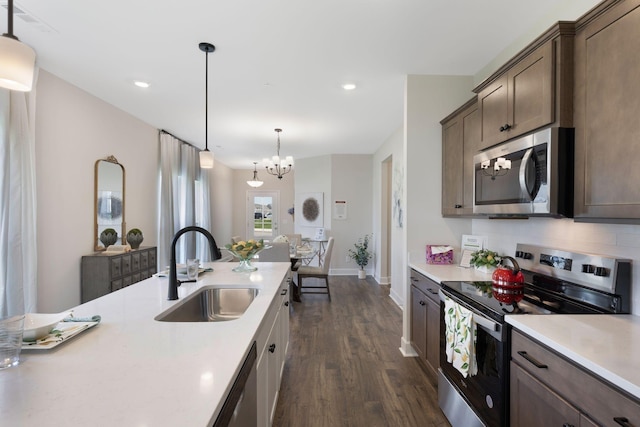 kitchen with decorative light fixtures, sink, backsplash, dark hardwood / wood-style flooring, and stainless steel appliances