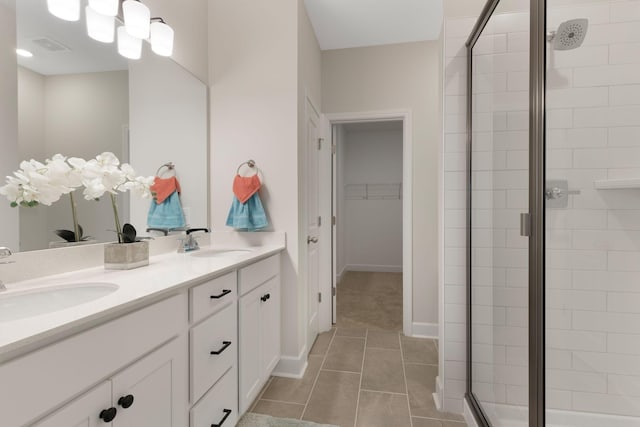 bathroom with vanity, a shower with shower door, and tile patterned floors