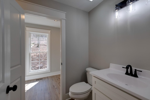 bathroom featuring vanity, hardwood / wood-style floors, and toilet