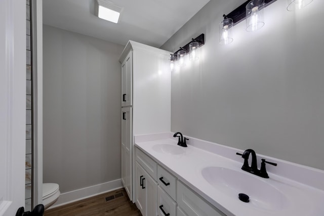 bathroom with vanity, hardwood / wood-style flooring, and toilet