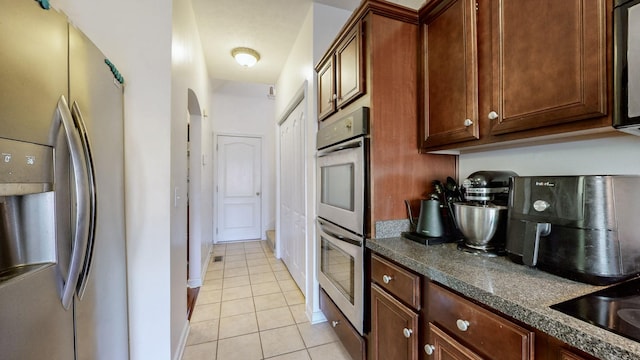 kitchen featuring light tile patterned flooring and appliances with stainless steel finishes