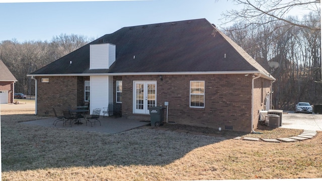 rear view of property with a patio area, central air condition unit, and a lawn