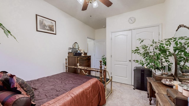 bedroom featuring light carpet, ceiling fan, and a closet