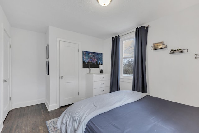 bedroom with dark wood-type flooring and a textured ceiling