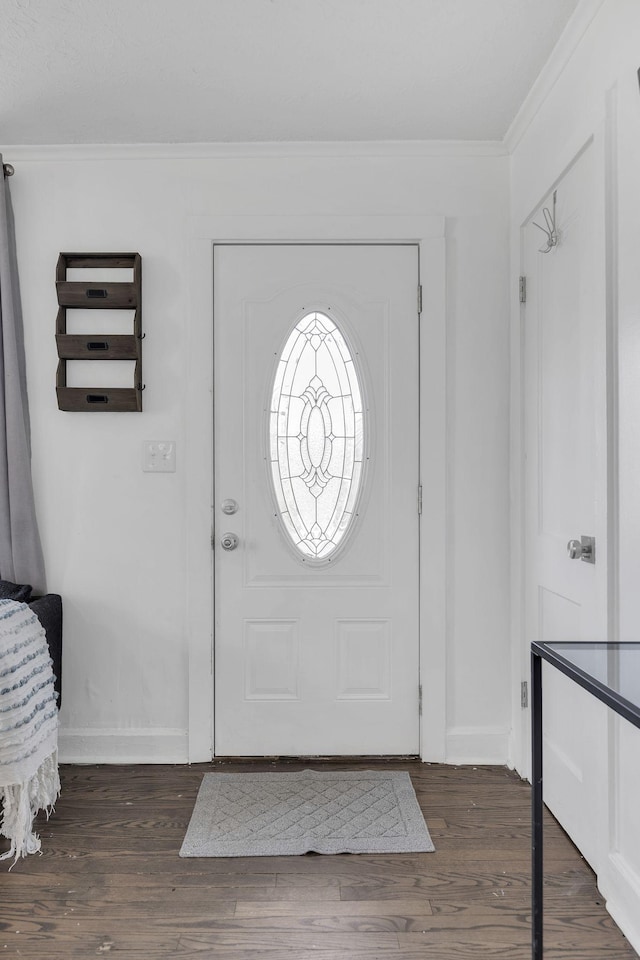 entrance foyer featuring dark hardwood / wood-style flooring and crown molding