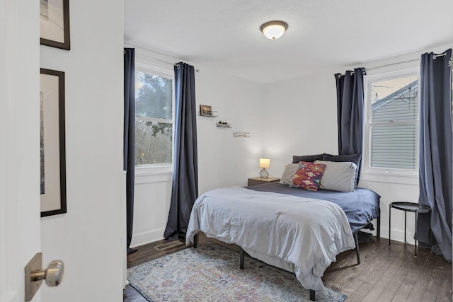 bedroom with hardwood / wood-style floors, multiple windows, and a textured ceiling