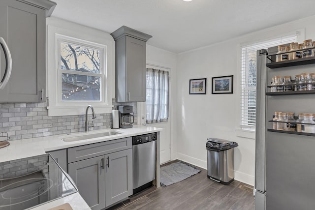 kitchen with stainless steel dishwasher, a healthy amount of sunlight, gray cabinets, and sink