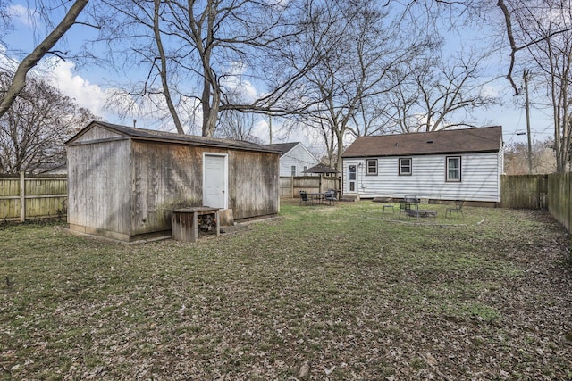 back of property with an outbuilding and a lawn