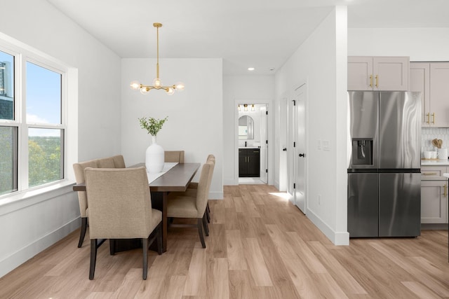 dining area featuring light hardwood / wood-style flooring and a chandelier