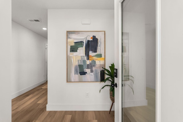 hallway with hardwood / wood-style floors