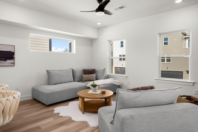 living room with light hardwood / wood-style floors and ceiling fan