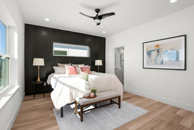 bedroom featuring ceiling fan, connected bathroom, and light hardwood / wood-style floors