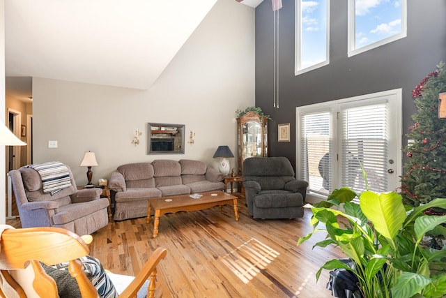 living room with a towering ceiling and light wood-type flooring