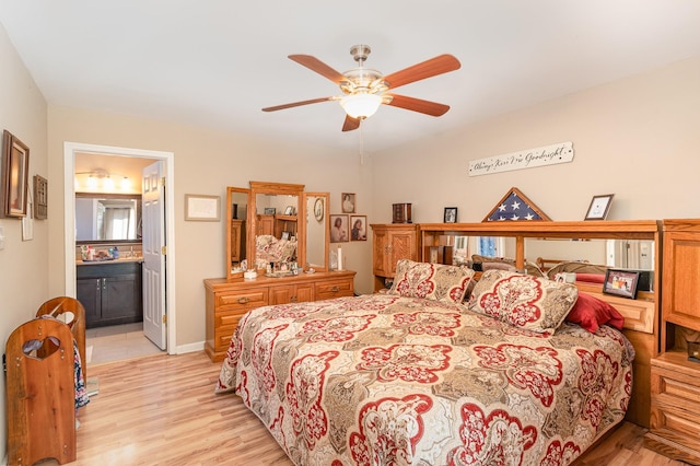 bedroom with ceiling fan, ensuite bath, and light wood-type flooring