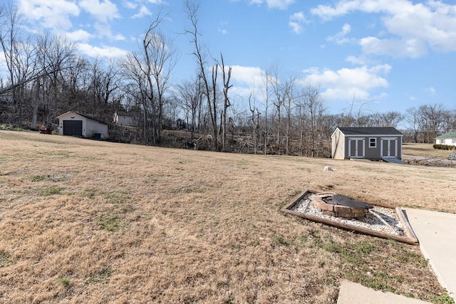 view of yard with a storage unit and an outdoor fire pit