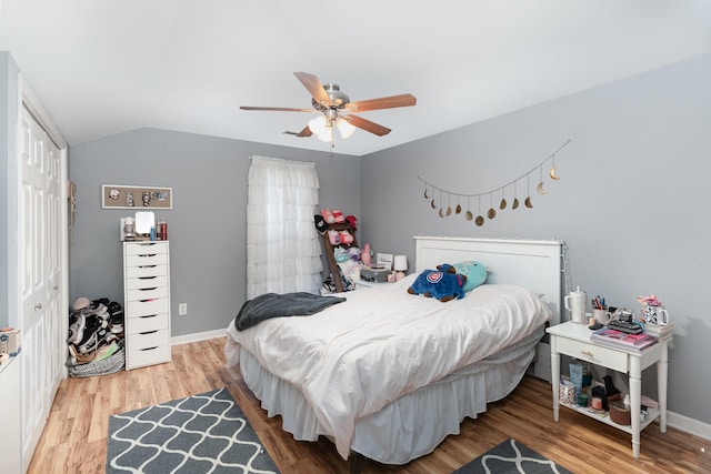 bedroom featuring hardwood / wood-style floors, vaulted ceiling, a closet, and ceiling fan