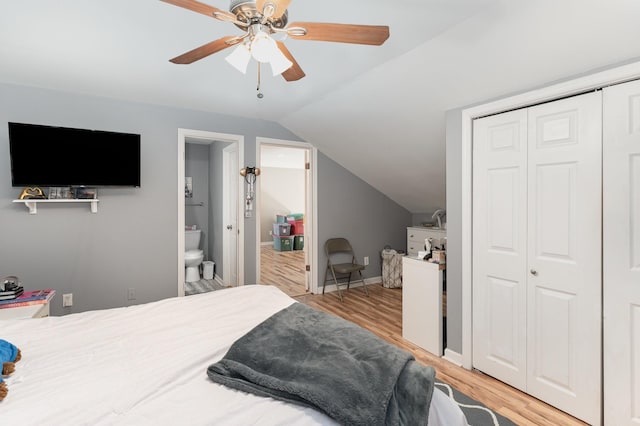 bedroom with lofted ceiling, ceiling fan, ensuite bathroom, a closet, and light wood-type flooring