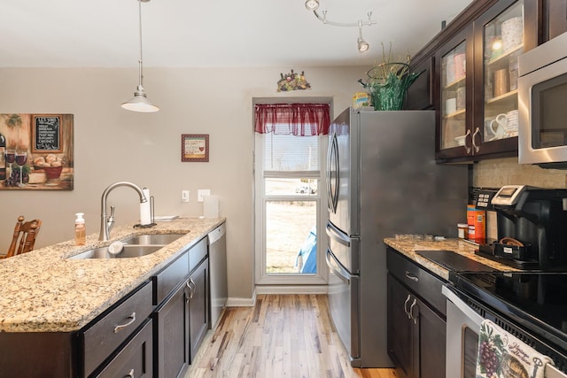 kitchen with sink, dark brown cabinets, stainless steel appliances, and hanging light fixtures