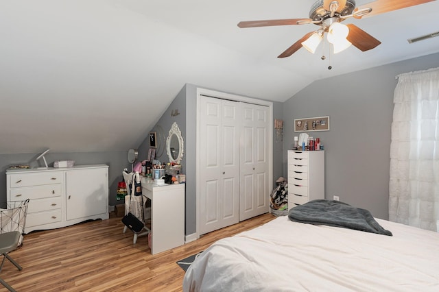 bedroom with a closet, ceiling fan, vaulted ceiling, and light hardwood / wood-style flooring