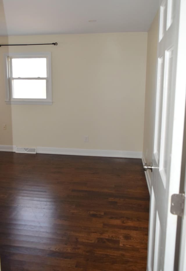 unfurnished room featuring dark hardwood / wood-style flooring