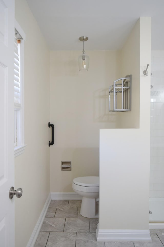 bathroom featuring tile patterned floors, toilet, and a shower