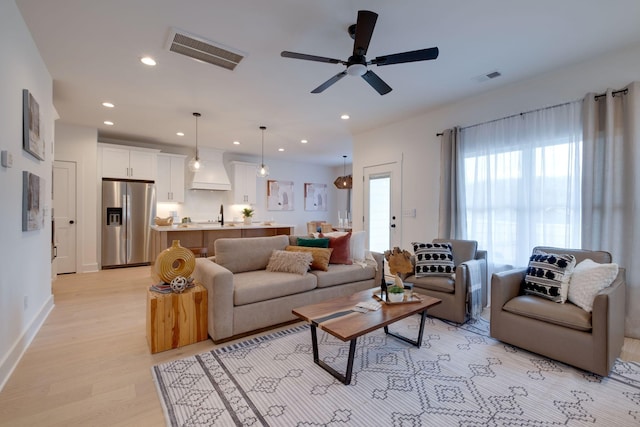 living room featuring light hardwood / wood-style floors and ceiling fan