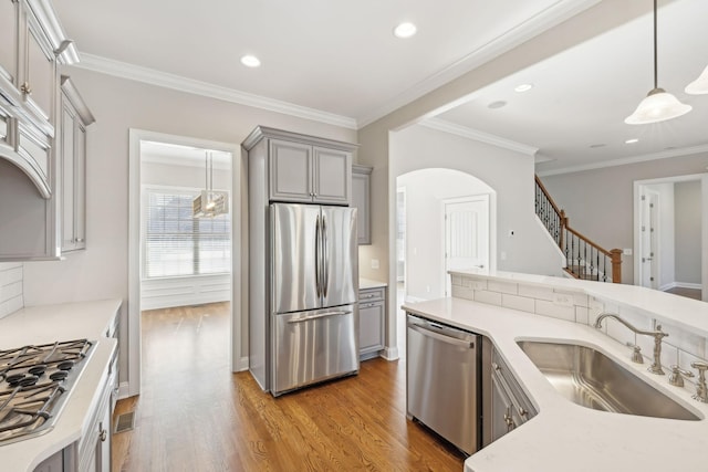 kitchen with pendant lighting, stainless steel appliances, sink, and gray cabinetry