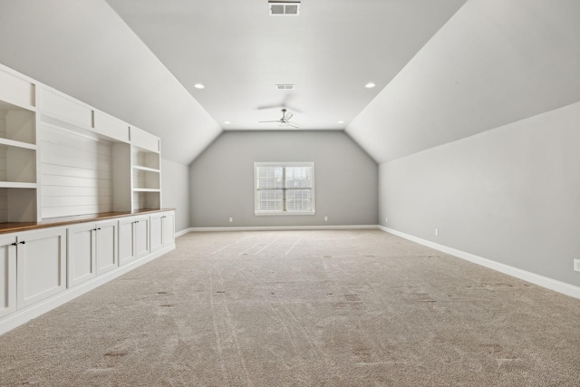 bonus room featuring ceiling fan, light colored carpet, vaulted ceiling, and built in features