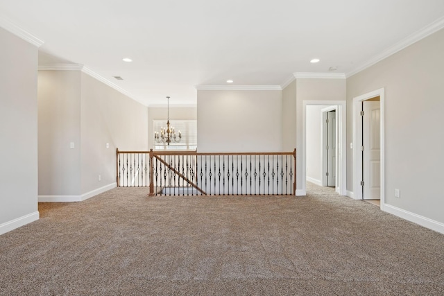 spare room featuring an inviting chandelier, carpet floors, and ornamental molding