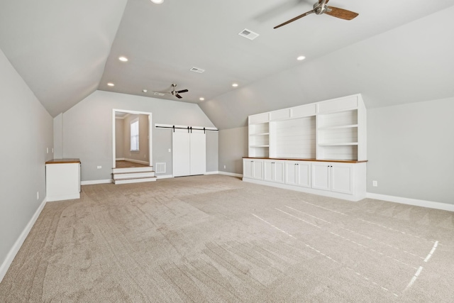 additional living space with vaulted ceiling, light colored carpet, and ceiling fan