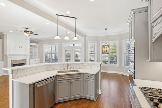 kitchen with gray cabinetry, sink, pendant lighting, and appliances with stainless steel finishes