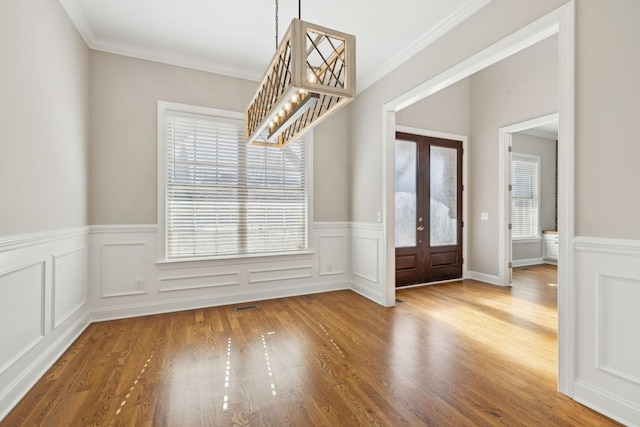 entryway featuring french doors, ornamental molding, plenty of natural light, and wood-type flooring