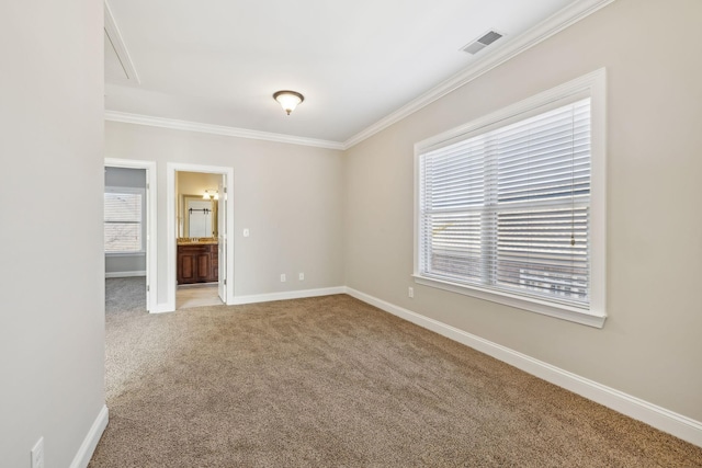 empty room with crown molding, a wealth of natural light, and carpet