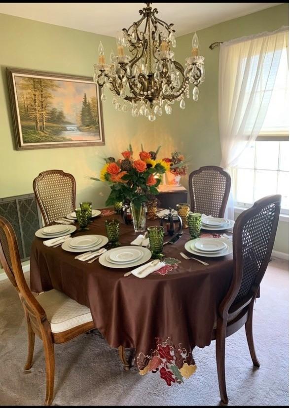 dining space with a notable chandelier and carpet floors